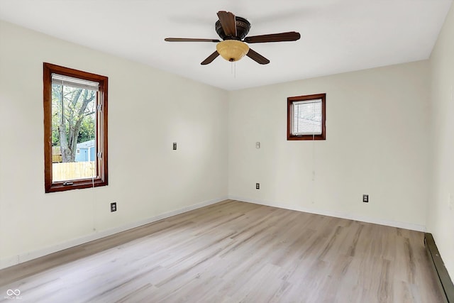 empty room featuring ceiling fan, baseboards, light wood-style floors, and a baseboard radiator