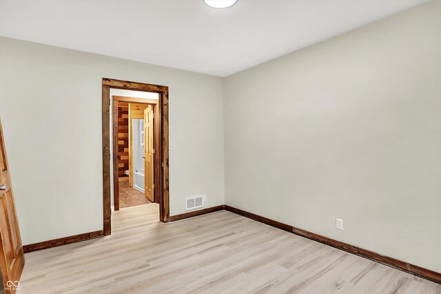 spare room with visible vents, light wood-style flooring, and baseboards
