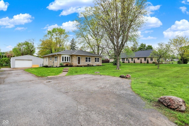 ranch-style house with a garage, a front lawn, an outbuilding, and stone siding