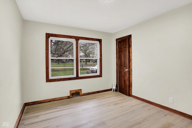 empty room featuring light wood-type flooring and baseboards