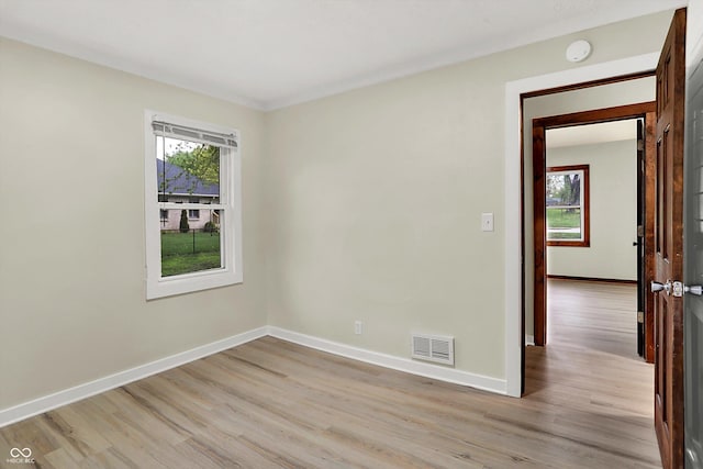 spare room with visible vents, baseboards, and light wood-style floors