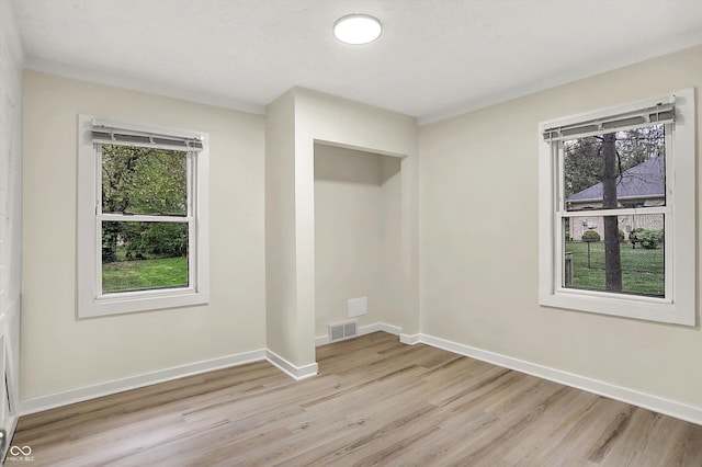 spare room with visible vents, baseboards, and light wood-type flooring