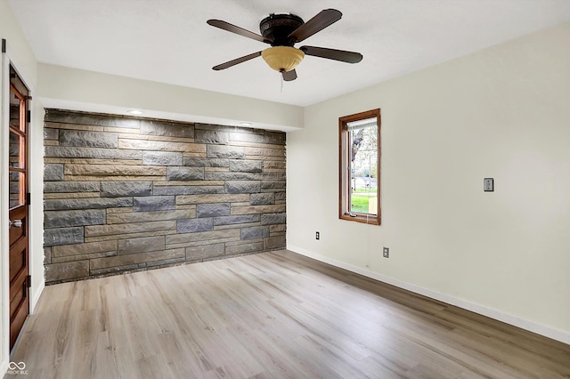 unfurnished room featuring wood finished floors, ceiling fan, and baseboards