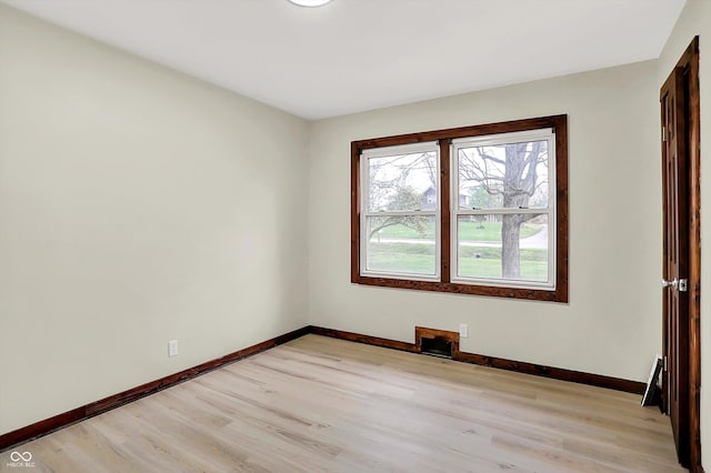 unfurnished room with light wood finished floors and baseboards
