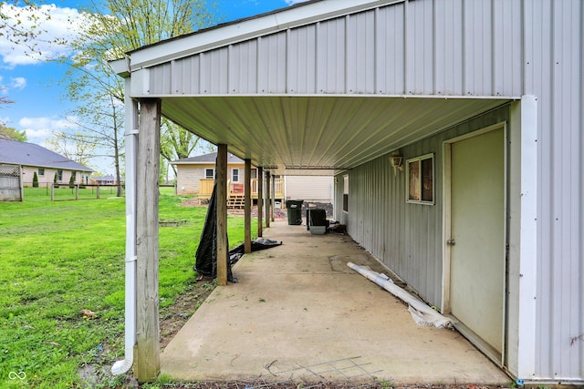 view of vehicle parking featuring an attached carport and fence