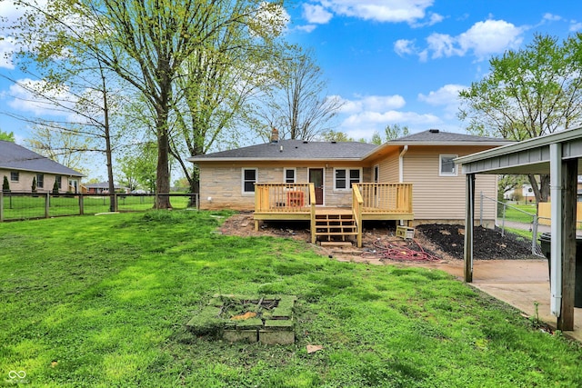 rear view of property with a deck, a chimney, a fenced backyard, and a lawn
