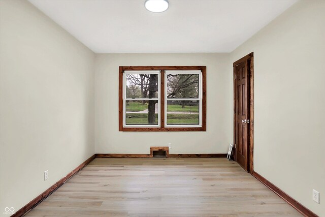 unfurnished room with baseboards and light wood-type flooring