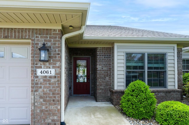 doorway to property with brick siding and a garage