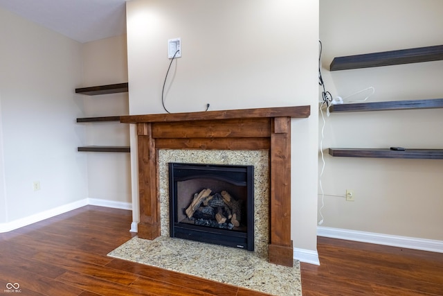 details with baseboards, wood finished floors, and a high end fireplace