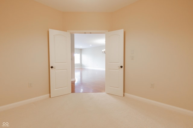 empty room with baseboards and light colored carpet