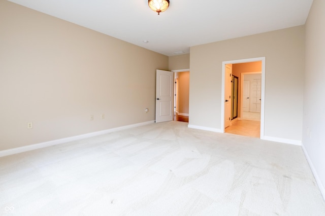 unfurnished bedroom featuring baseboards, light carpet, and connected bathroom