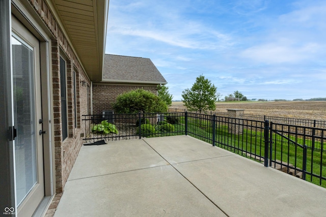 view of patio / terrace featuring a rural view and fence