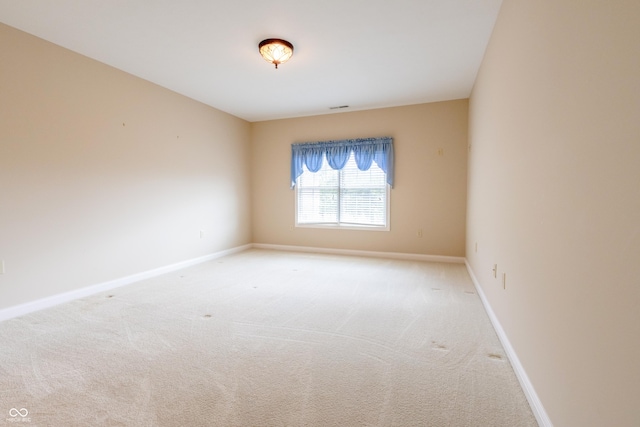 carpeted empty room with baseboards and visible vents