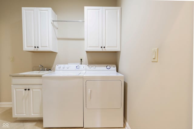 clothes washing area featuring cabinet space, baseboards, a sink, and washer and clothes dryer