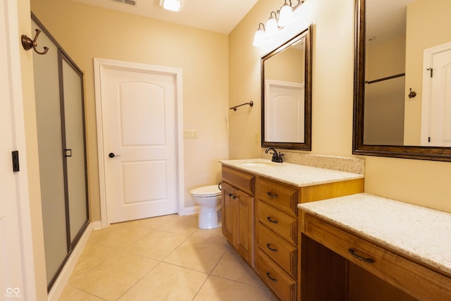 full bathroom with a stall shower, tile patterned floors, toilet, and vanity