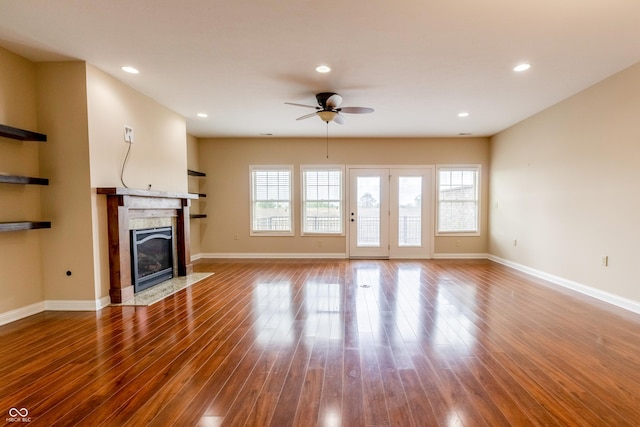 unfurnished living room with a ceiling fan, a fireplace with flush hearth, wood finished floors, baseboards, and recessed lighting