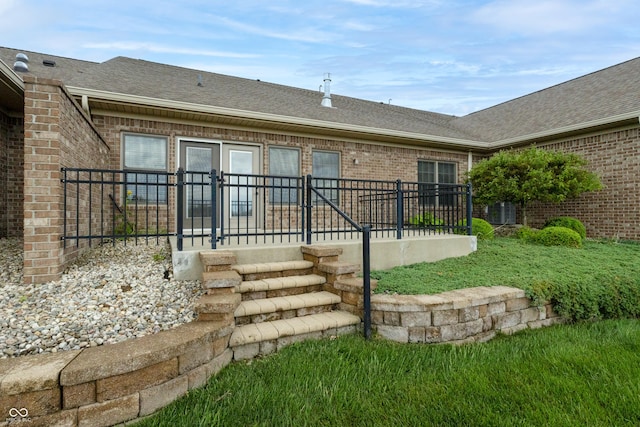 back of property featuring roof with shingles, central air condition unit, and brick siding