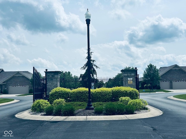 community / neighborhood sign featuring fence