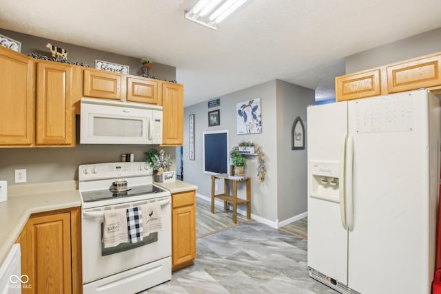 kitchen with baseboards, white appliances, and light countertops