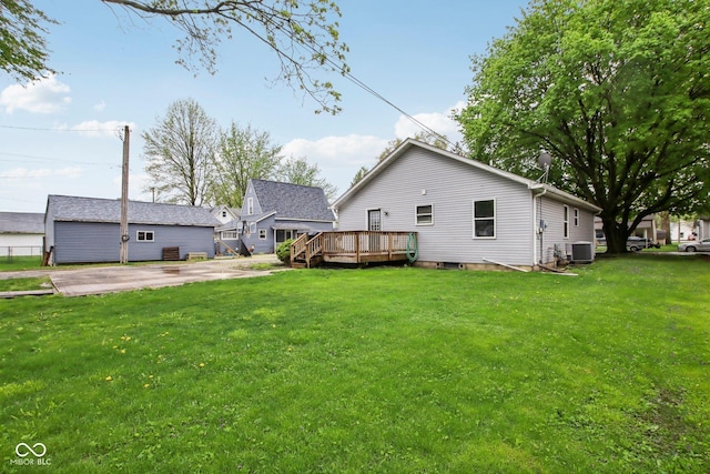 rear view of house featuring a lawn, a wooden deck, and central air condition unit