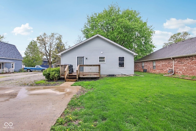back of property with a lawn and a wooden deck