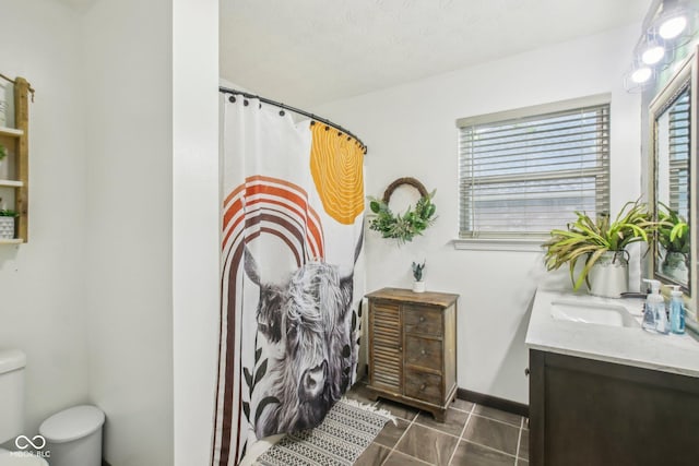 full bathroom featuring toilet, tile patterned flooring, vanity, and baseboards