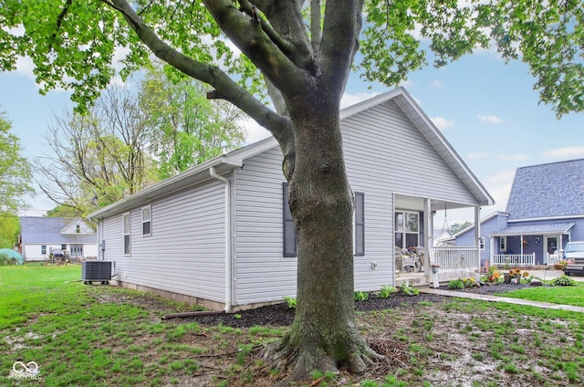 view of side of property with a lawn and central air condition unit