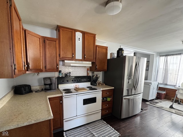 kitchen with stainless steel fridge, electric range, under cabinet range hood, light countertops, and brown cabinets