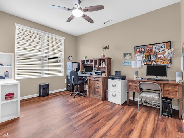 home office featuring wood finished floors, ceiling fan, visible vents, and baseboards