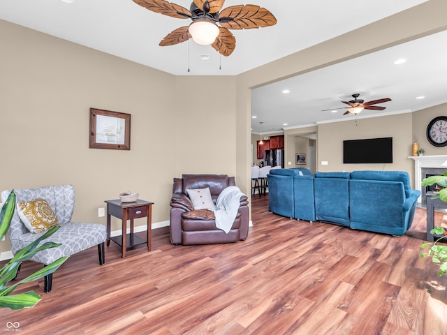 living room featuring recessed lighting, light wood finished floors, ceiling fan, and baseboards