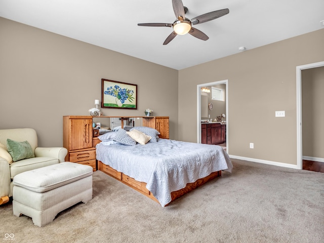carpeted bedroom featuring ceiling fan, ensuite bath, and baseboards