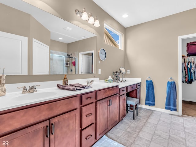 full bath with double vanity, a walk in closet, a shower stall, and a sink