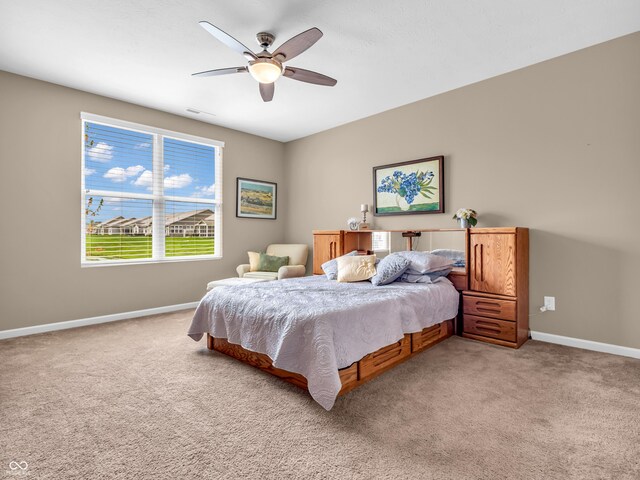 bedroom featuring visible vents, baseboards, a ceiling fan, and light carpet