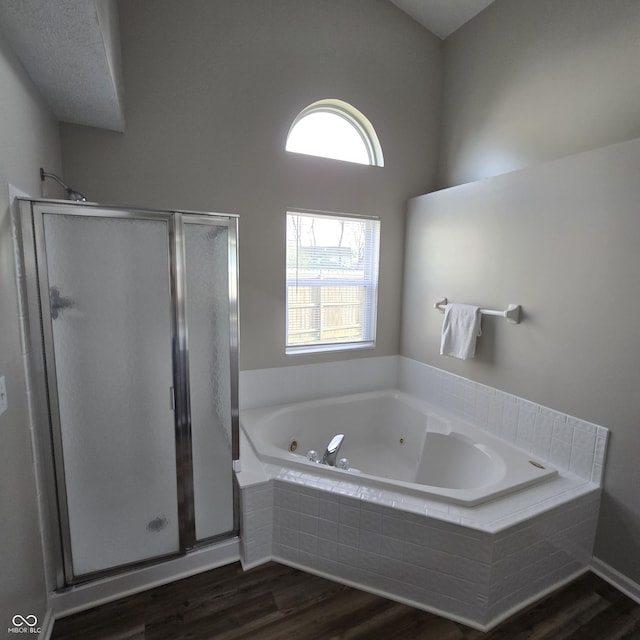 bathroom featuring a stall shower, wood finished floors, and a jetted tub