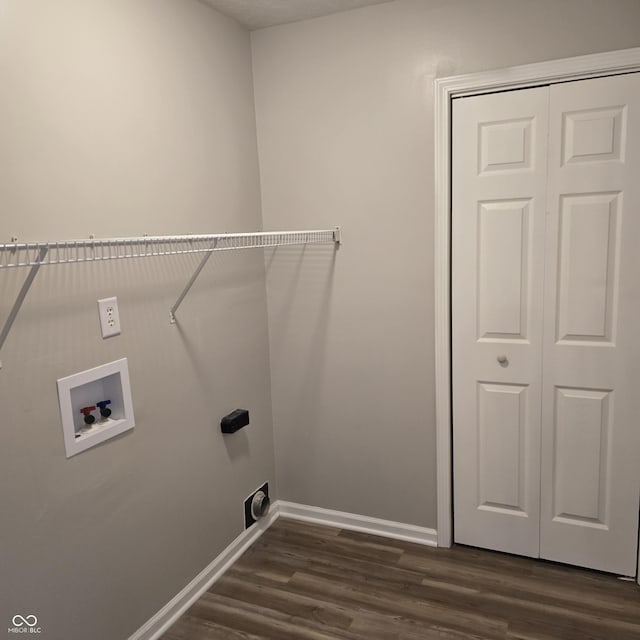 clothes washing area with baseboards, washer hookup, laundry area, and dark wood finished floors