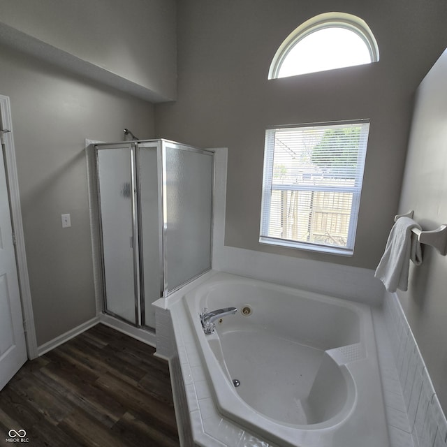bathroom with wood finished floors, a shower stall, and a bath