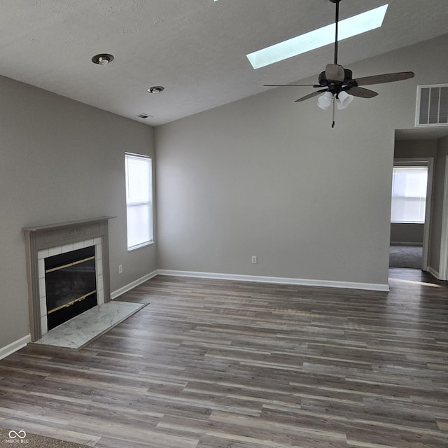 unfurnished living room featuring a fireplace, wood finished floors, visible vents, and baseboards
