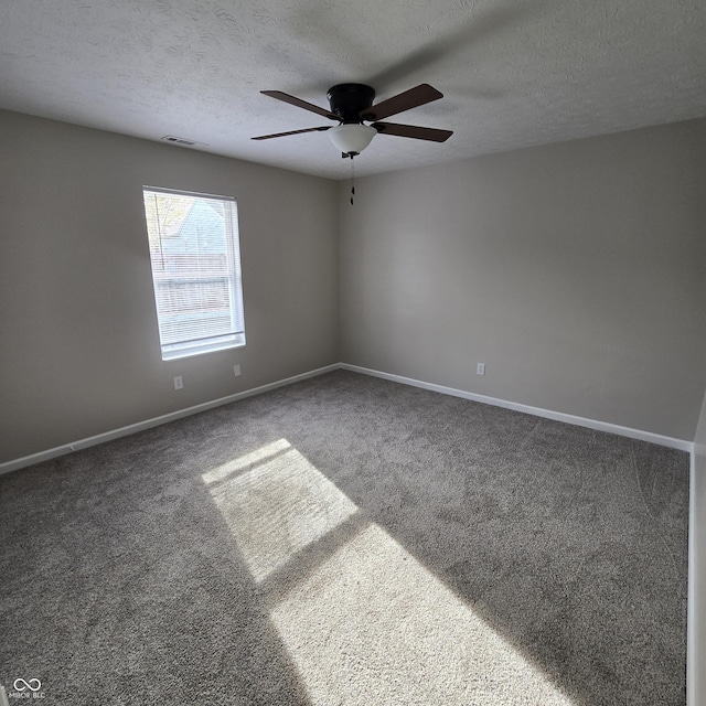 carpeted spare room featuring baseboards, visible vents, ceiling fan, and a textured ceiling