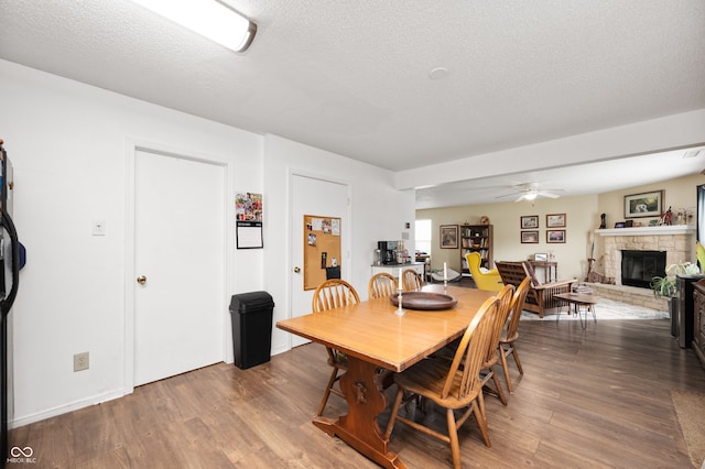 8211 Firefly Way, Indianapolis, IN 46259 - dining space featuring a ceiling fan, wood finished floors, a fireplace, and a textured ceiling