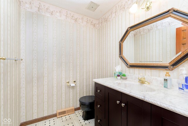 7901 Oaklandon Rd, Indianapolis, IN 46236 - bathroom with vanity, toilet, baseboards, wallpapered walls, and visible vents