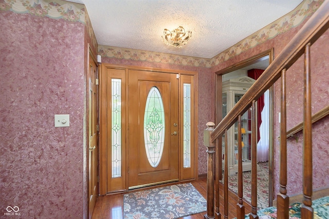 7901 Oaklandon Rd, Indianapolis, IN 46236 - foyer entrance featuring a textured ceiling, wood finished floors, stairway, and wallpapered walls