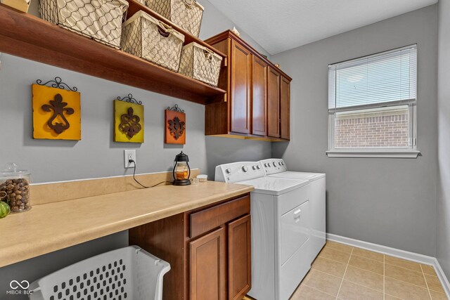 4809 Ozark Ln, Indianapolis, IN 46239 - laundry area with light tile patterned floors, washer and dryer, cabinet space, and baseboards