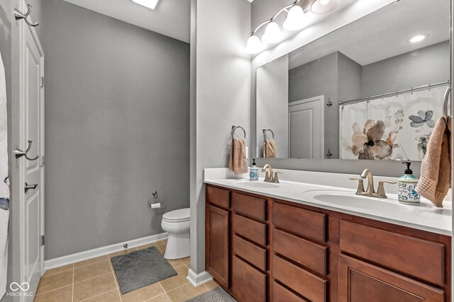 4809 Ozark Ln, Indianapolis, IN 46239 - bathroom with toilet, tile patterned flooring, a sink, and baseboards