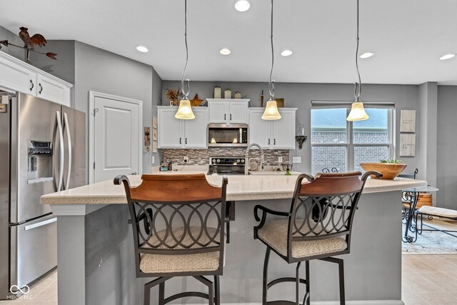 4809 Ozark Ln, Indianapolis, IN 46239 - kitchen featuring light tile patterned floors, white cabinetry, stainless steel appliances, and decorative backsplash