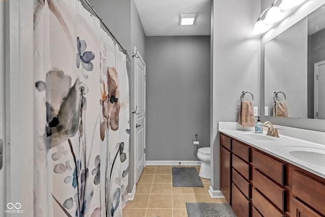 4809 Ozark Ln, Indianapolis, IN 46239 - full bath with a sink, double vanity, baseboards, toilet, and tile patterned floors