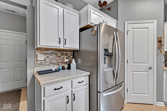 4809 Ozark Ln, Indianapolis, IN 46239 - kitchen featuring visible vents, stainless steel refrigerator with ice dispenser, backsplash, and white cabinets