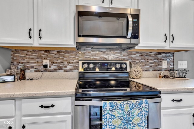 4809 Ozark Ln, Indianapolis, IN 46239 - kitchen with white cabinetry, light stone countertops, stainless steel appliances, and backsplash
