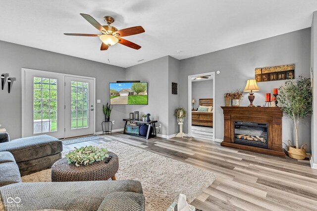 4809 Ozark Ln, Indianapolis, IN 46239 - living area featuring baseboards, wood finished floors, a ceiling fan, and a glass covered fireplace