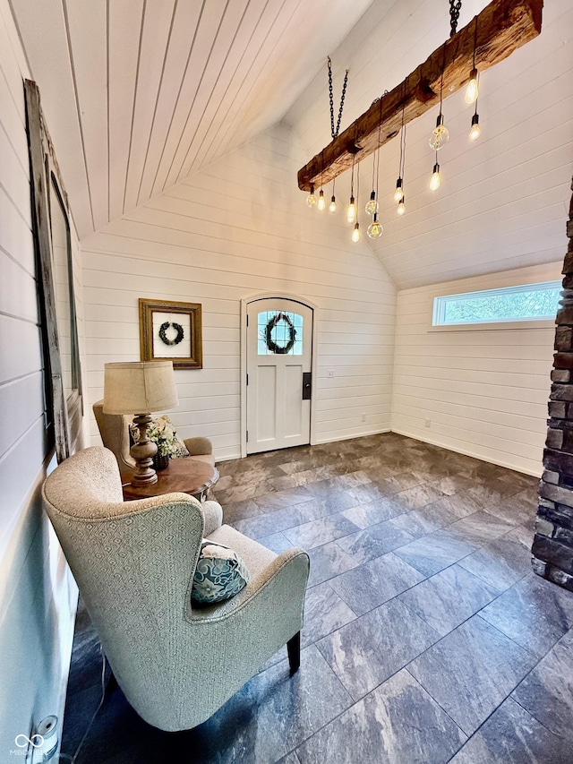 entrance foyer featuring wood walls, a healthy amount of sunlight, vaulted ceiling, and stone tile flooring