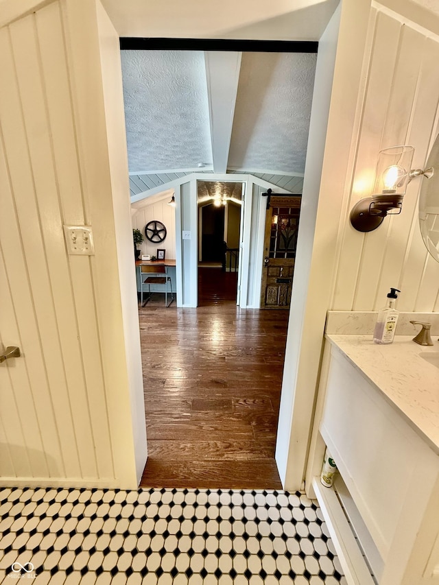hall with hardwood / wood-style floors and lofted ceiling